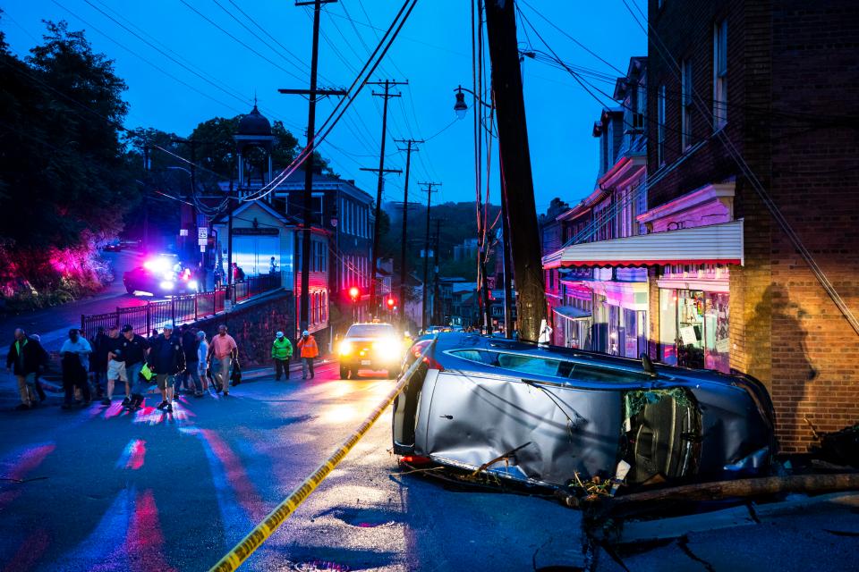  Damage to the Main Street is visible in Ellicott following the flood, as a car lies on its side against a shopfront in the city