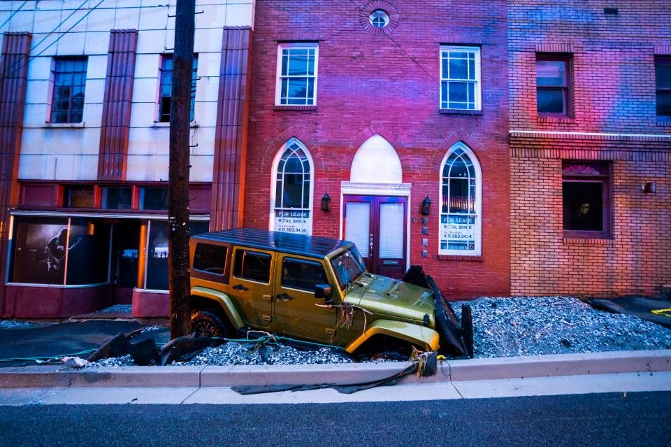  A jeep is discarded by the roadside after the floods