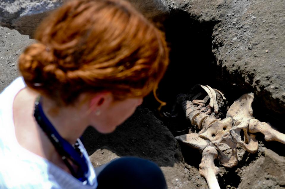  Anthropologist Valeria Amoretti looks at the victim's skeleton