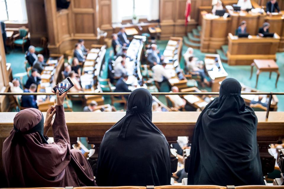  Women in veils sit in the public gallery inside the Danish parliament today