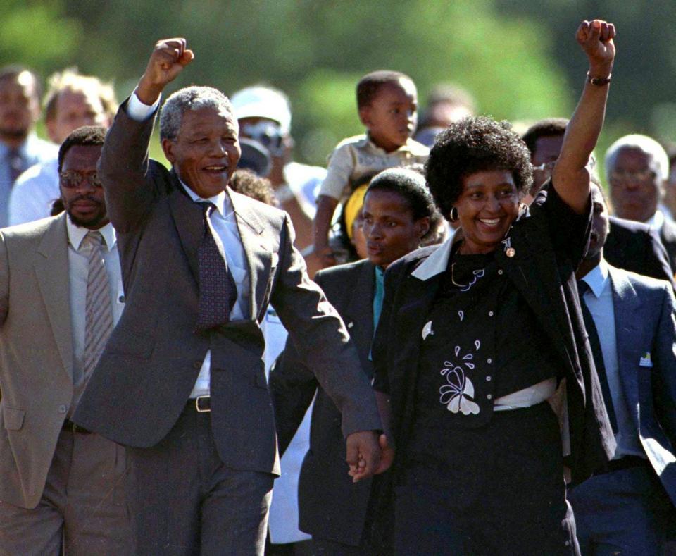 Nelson Mandela gestures as he is accompanied by his wife Winnie, moments after his release from Victor Verster prison in Western Cape