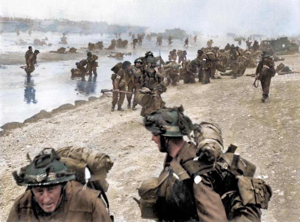  British troops show their true grit as they help injured comrades onto Sword Beach