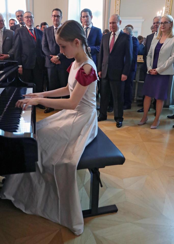  Putin and Austrian Chancellor Sebastian Kurz (third right) listen on as 13-year-old pianist Alma plays