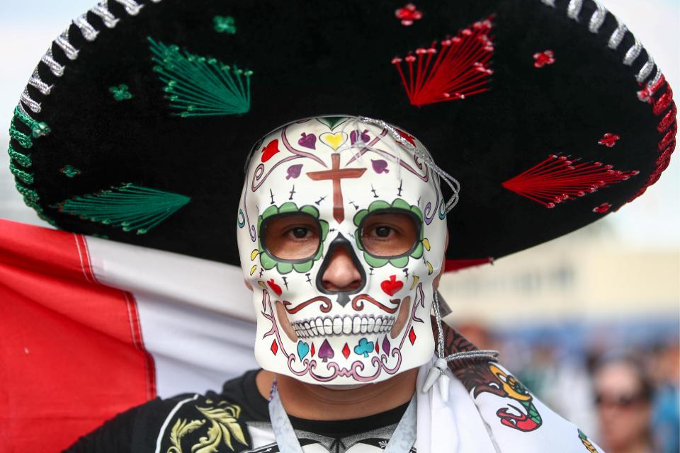  A Mexican fan wearing a traditional Day of the Dead mask