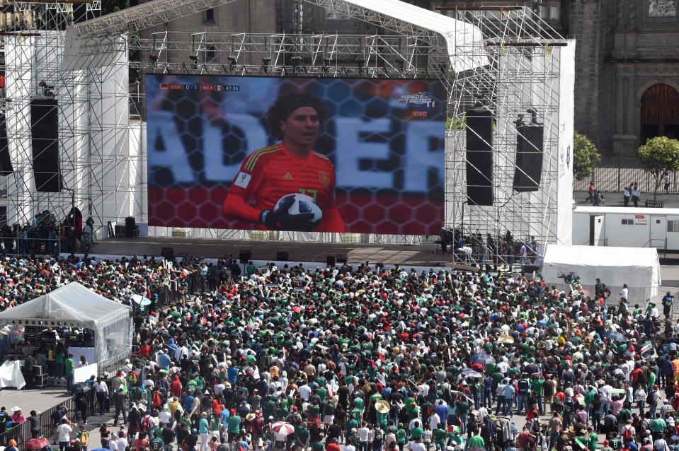  Fans look at the giant screen in the centre of Mexico City