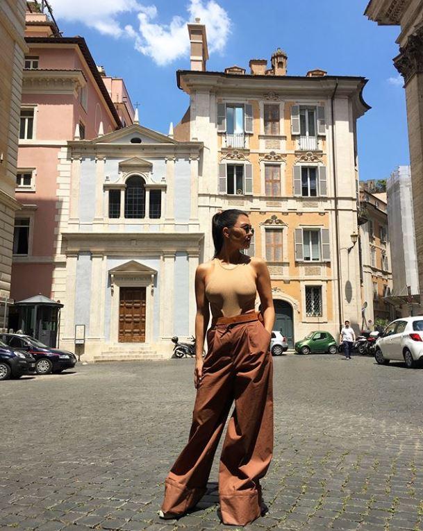  Kourtney poses in Rome, Italy in wed leg copper trousers and a simple beige crop