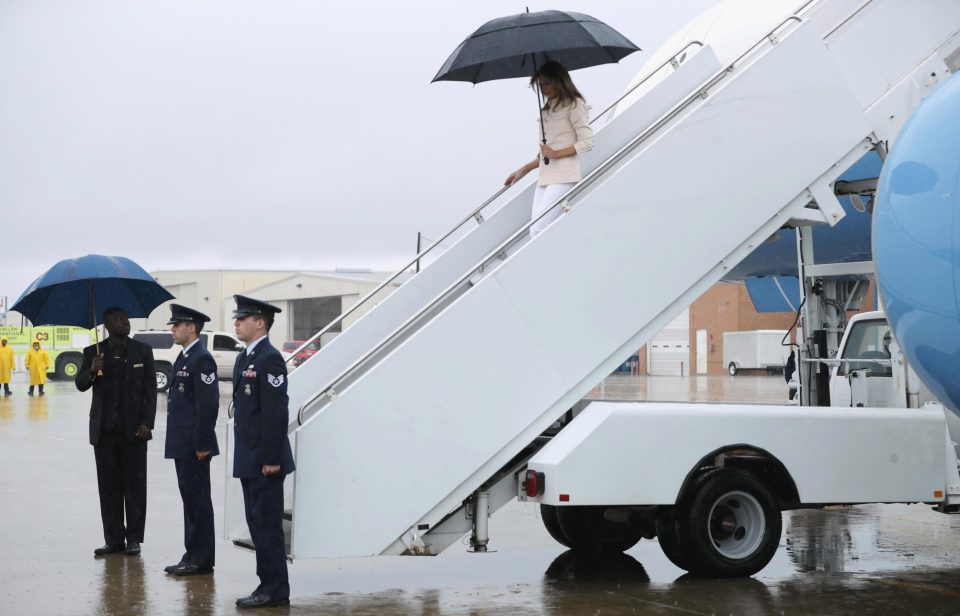  The first lady lands in rainy Texas in a cream coloured jacket and carrying an umbrella