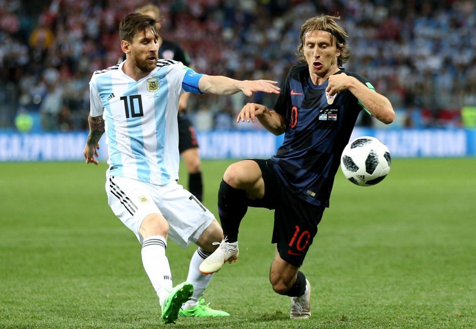  Barcelona and Real Madrid stars Leo Messi and Luka Modric battle for the ball