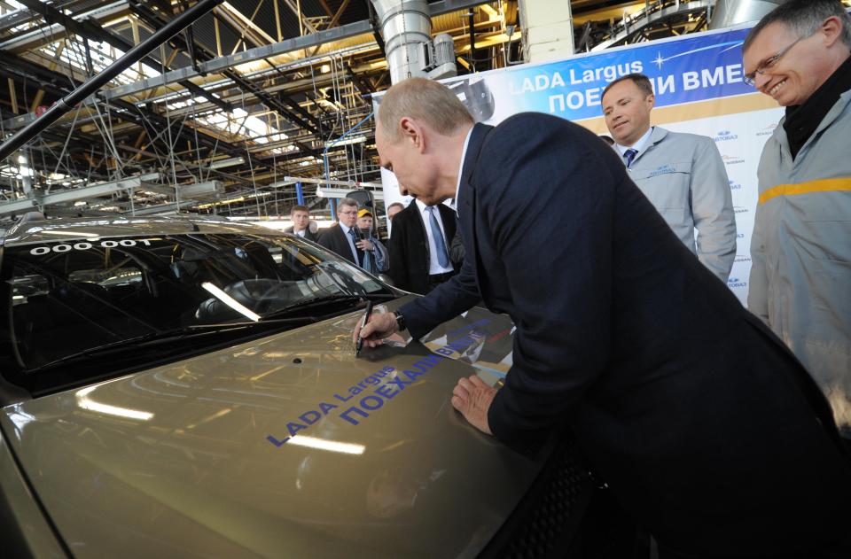  Vladimir Putin delights workers by autographing a new Lada Largus car