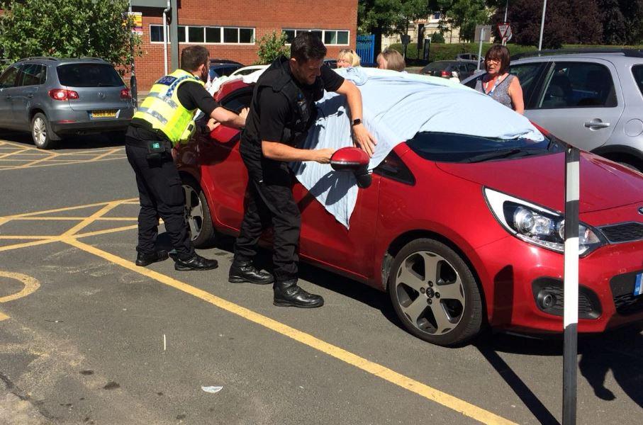  Two North Yorkshire police were forced to break into a car on Monday to free two dogs trapped in the heat