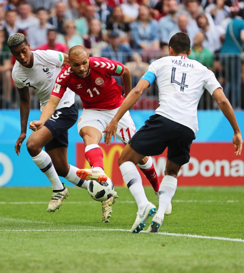 Denmark's Martin Braithwaite (C) attempts to find a way through past French stars Presnel Kimpembe (L) and Raphael Varane (R)