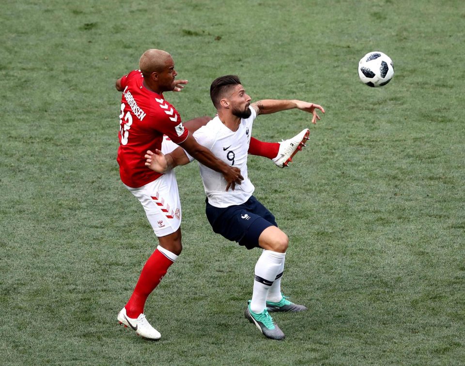 Olivier Giroud is tackled by Mathias Jorgensen during the Group C clash