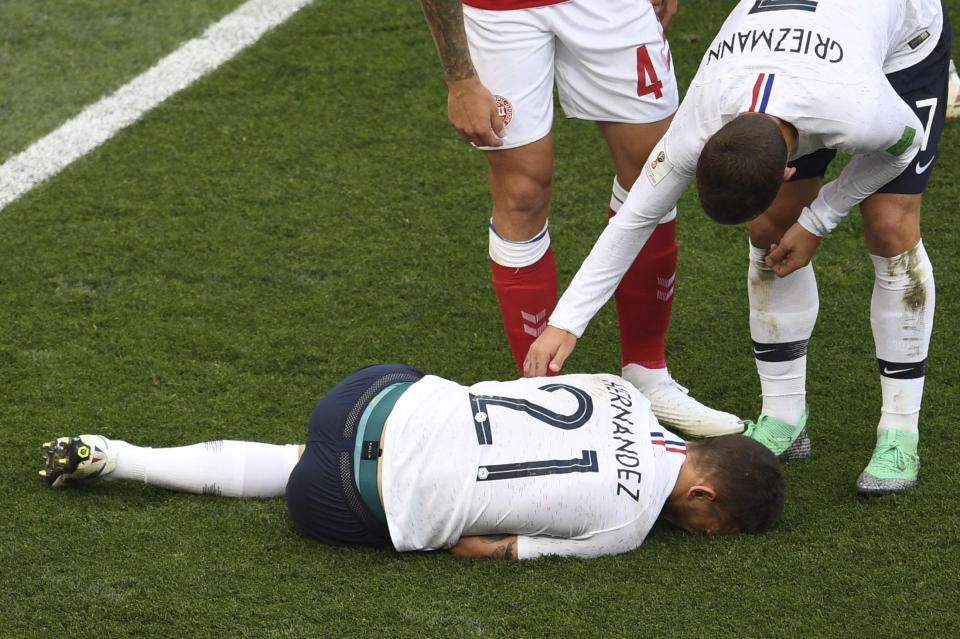 Antoine Griezmann (R) checks up on French defender Lucas Hernandez after the star was caught late by a Danish challenge