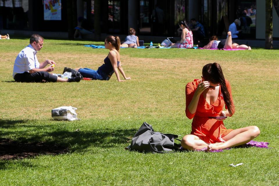 Londoners and tourists enjoy hot weather on Potters Fields near Tower Bridge