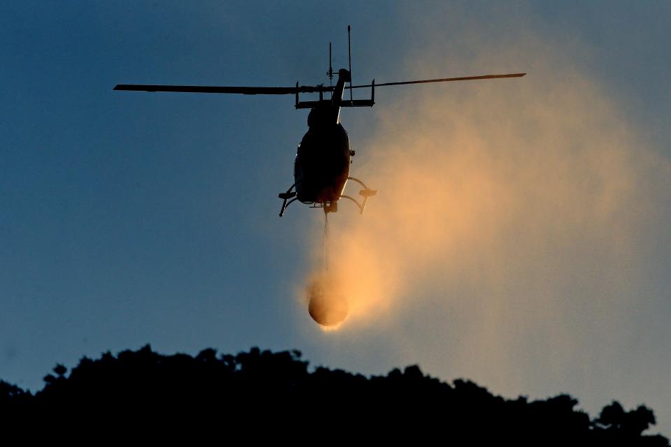  A helicopter drops water onto fires over the hills around Greenfield near Stalybridge in Greater Manchester as the fire continues to rage