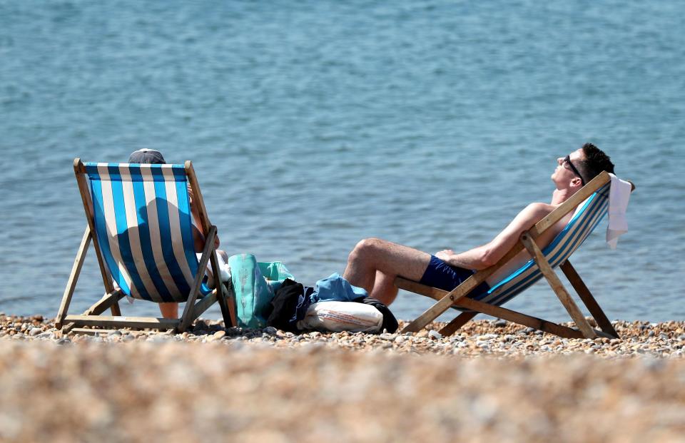  A couple enjoy the warm weather on the beach in Brighton, East Sussex