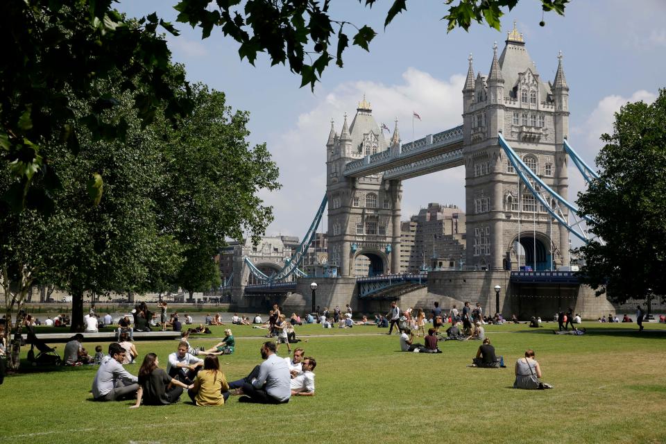 Londoners relax near Tower Bridge as the UK continues to bask in the sunshine