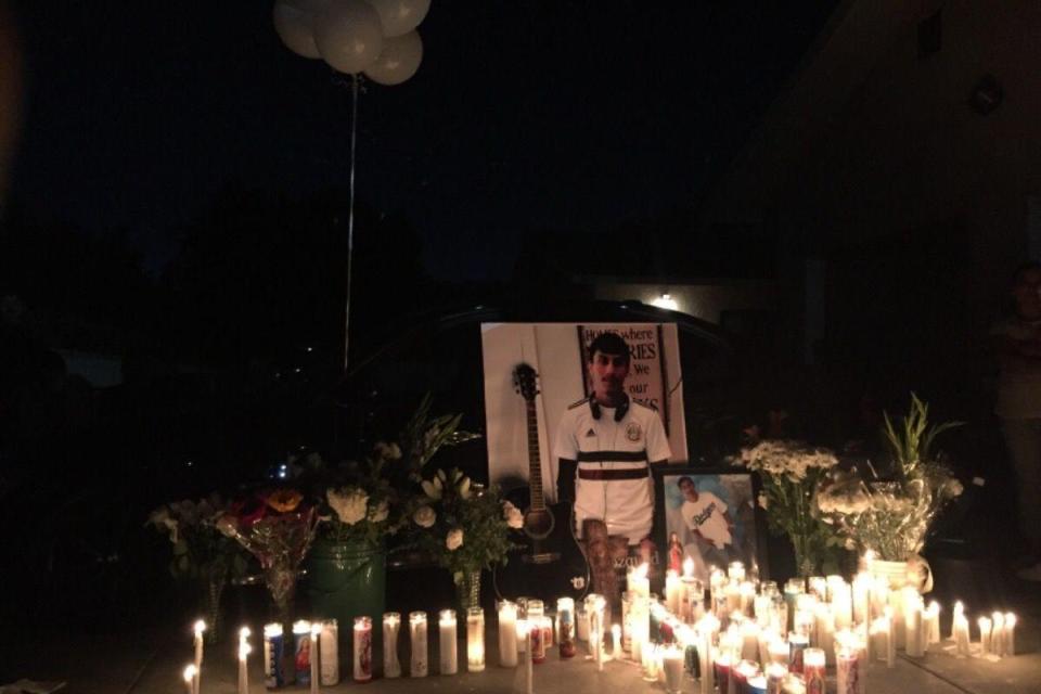  Candles are lit around a tribute to Victor