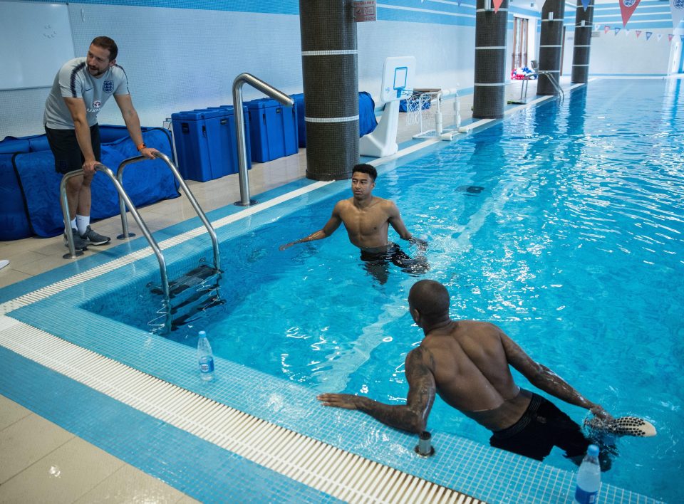  Jesse Lingard and Ashley Young stretch out their quads in the swimming pool