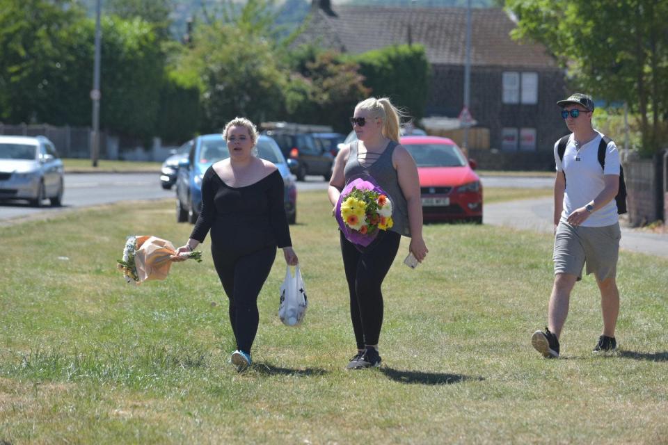  Locals lay flowers at the scene of the crash where four young people were killed