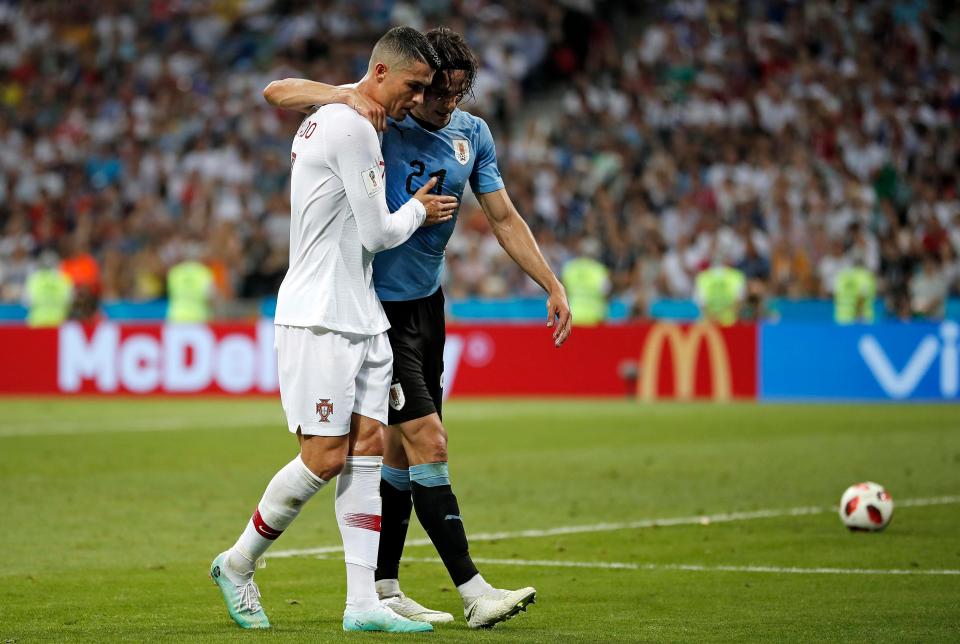 Cristiano Ronaldo helps carry Edinson Cavani off the pitch