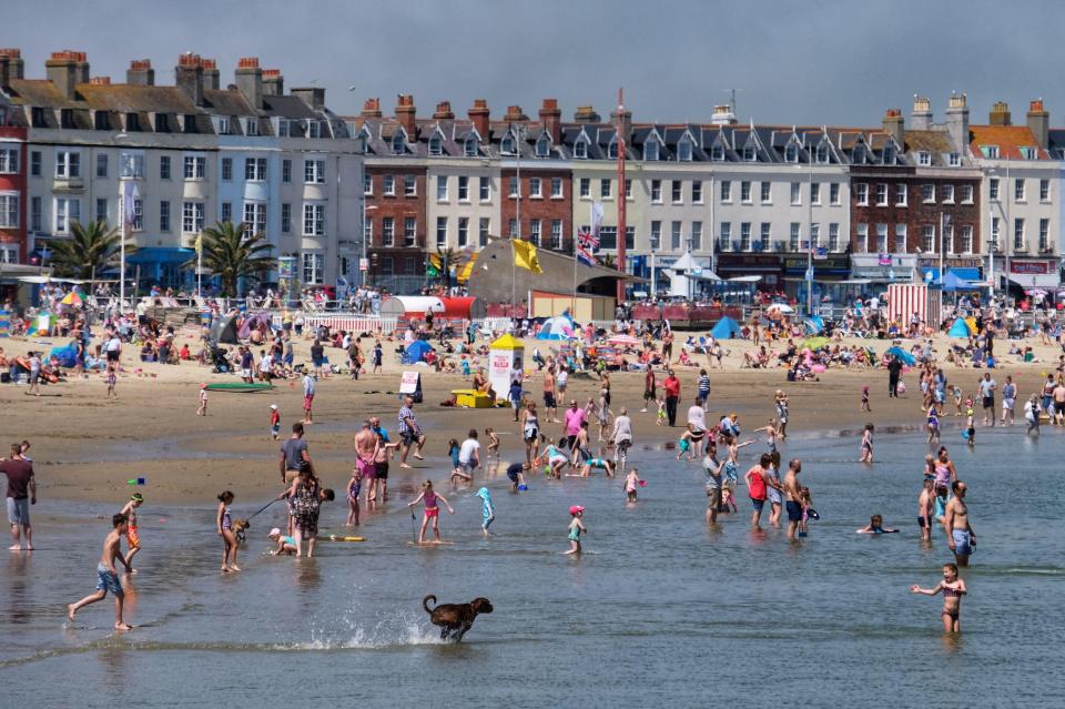  Revellers take to the water as temperatures soar in West Bay, Dorset