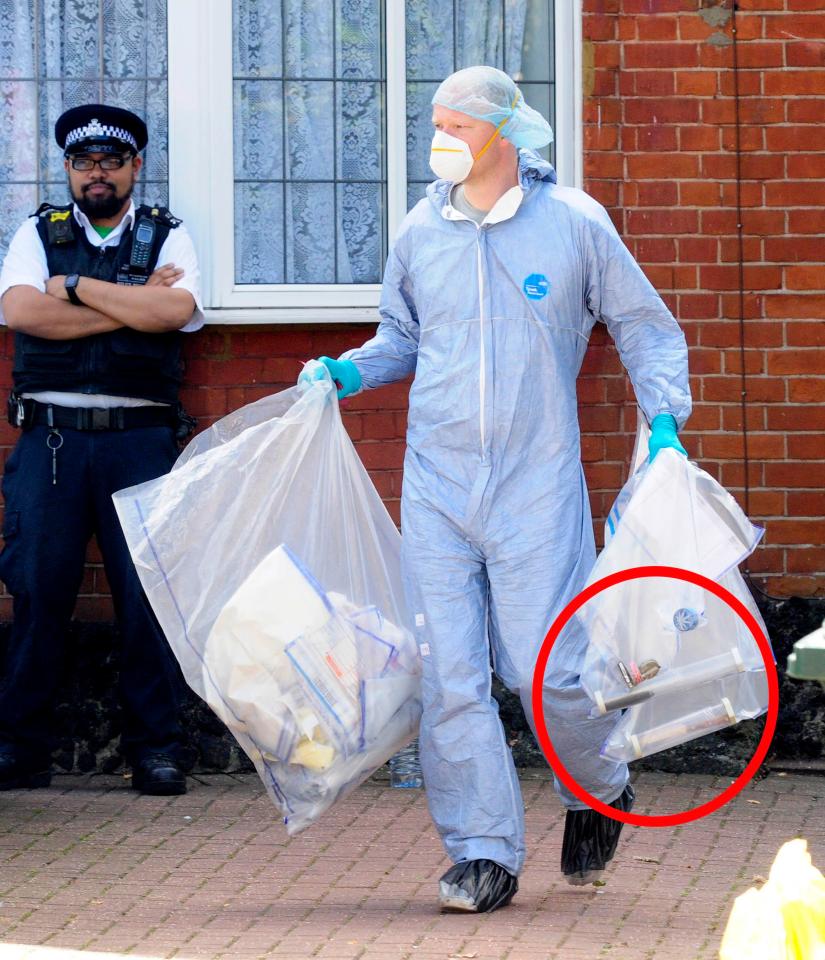  A forensic worker carries out a knife, placed in a tube, which was found in the Golders Green home of suspected double killer Joshua Cohen