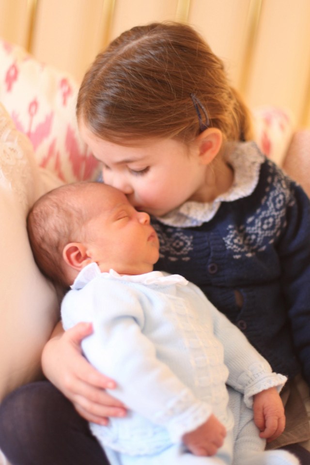 Charlotte gives her baby brother a kiss on the head