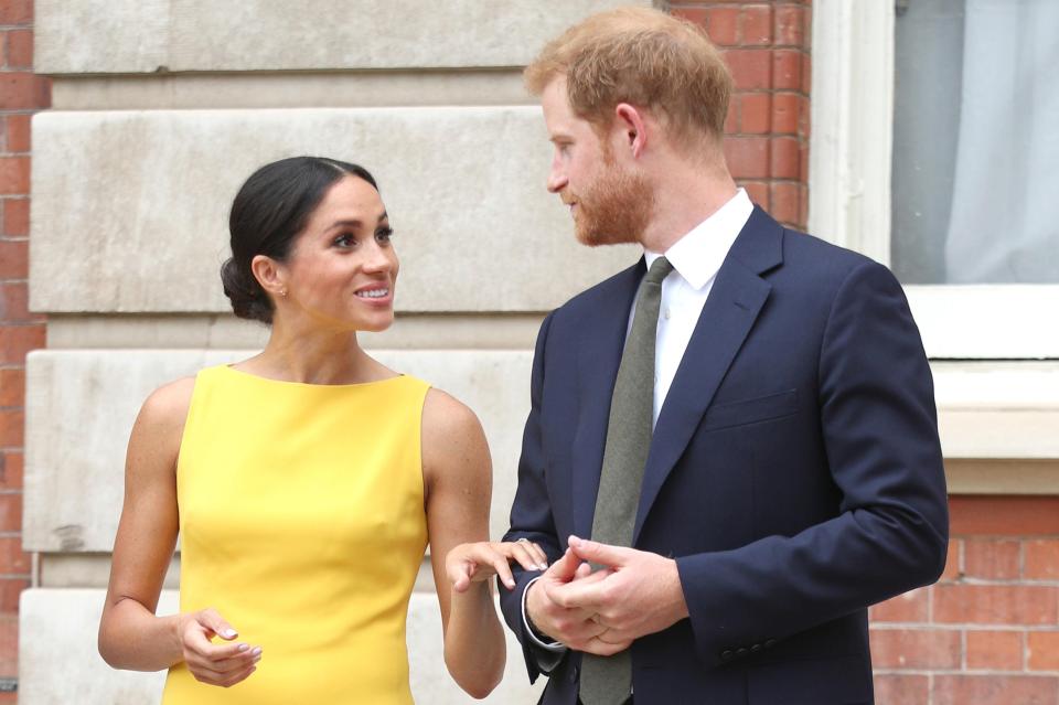  The Duchess of Sussex poses in a gorgeous yellow dress alongside husband Prince Harry