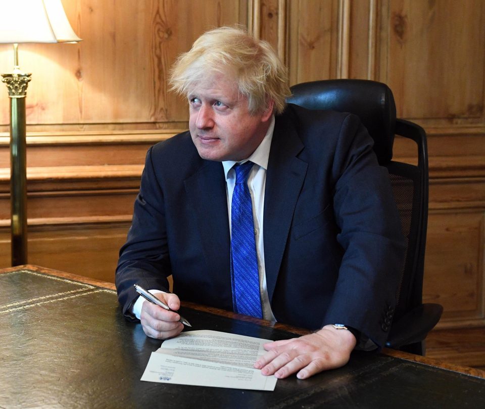  Boris Johnson poses for pictures while signing his resignation letter yesterday