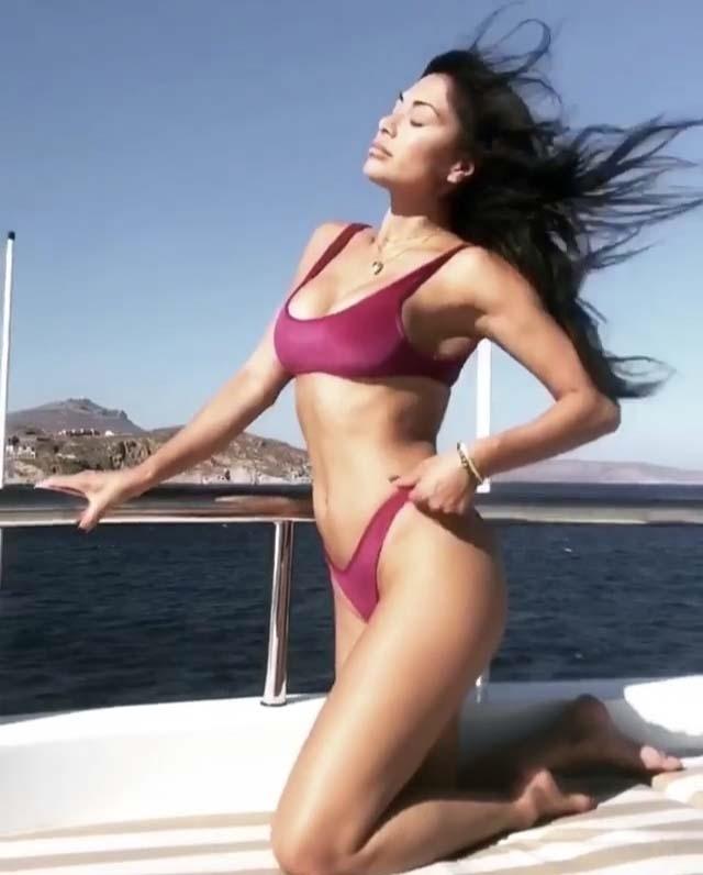 Nicole Scherzinger rocks her two piece as the wind blows her hair on a boat