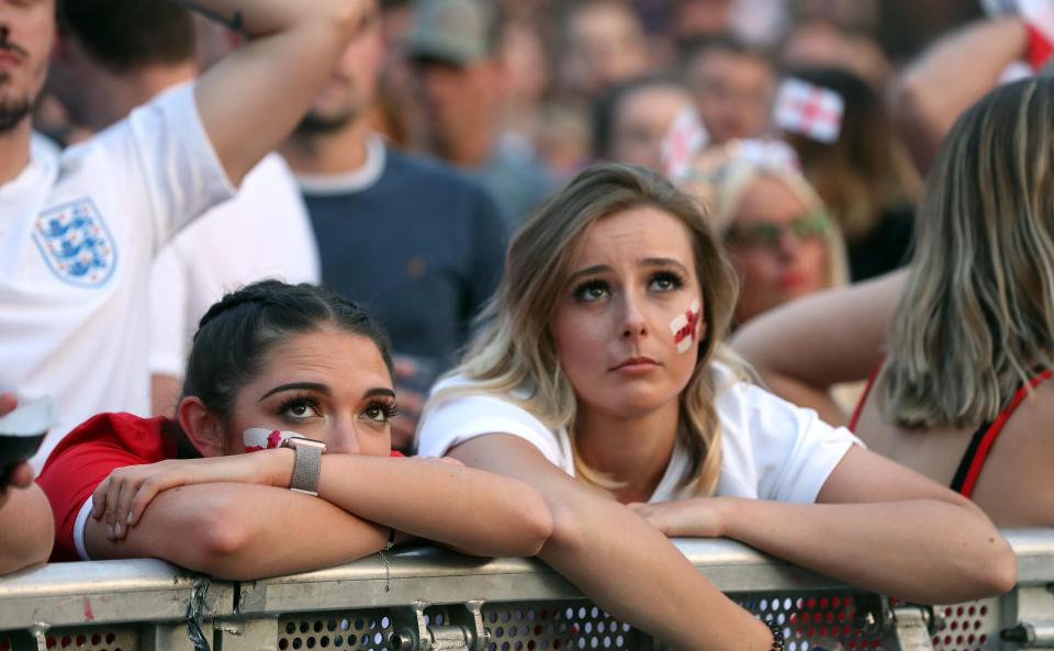 England fans slump against a barrier in Manchester amidst unbearable tension