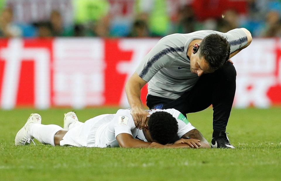 Marcus Rashford is dejected with his face down in the turf after England's loss