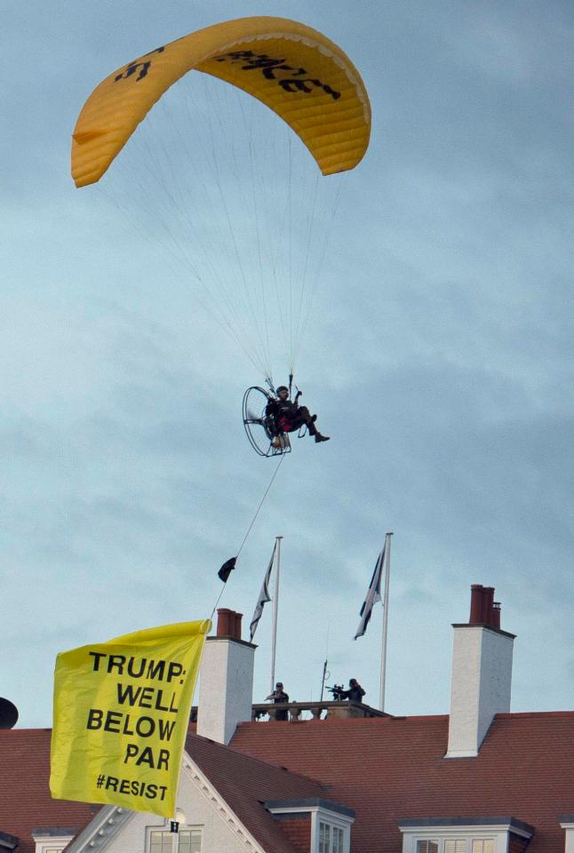  A protester swoops a few feet above the President's head as snipers on the roof aim their guns