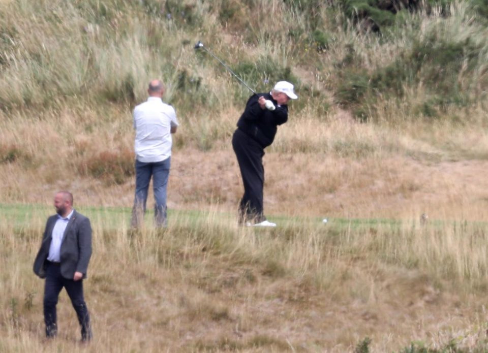  The US President was heavily guarded as he took aim at his resort in Turnberry - dressed in navy with a windshielder jacket