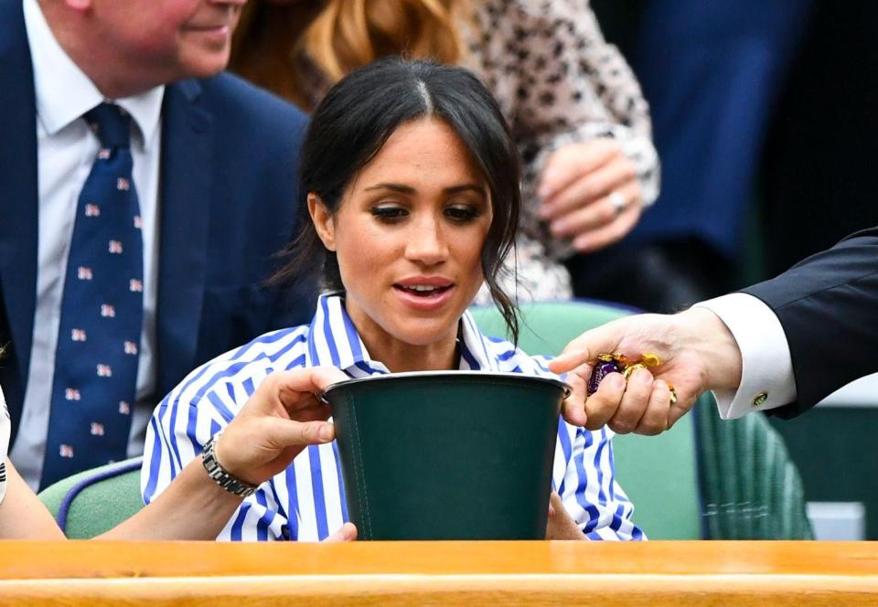  Meghan looks somewhat bemused as a bucket is proffered to her