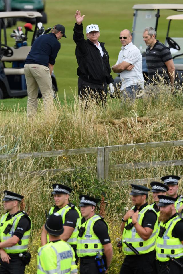  Donald Trump waves at protesters as he enjoyed golf with his son Eric