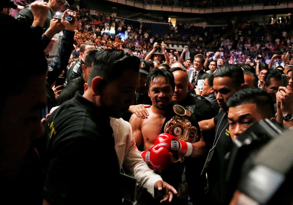 Pacquiao is mobbed by delighted fans as he departs victorious back to the dressing-room