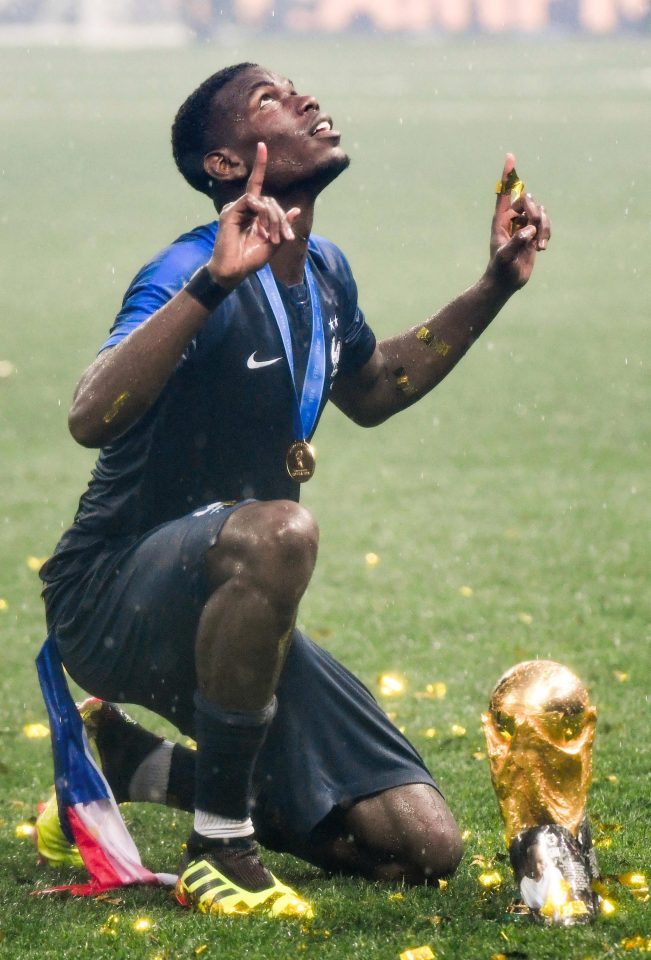 Pogba looks to the skies as he celebrates with the World Cup trophy