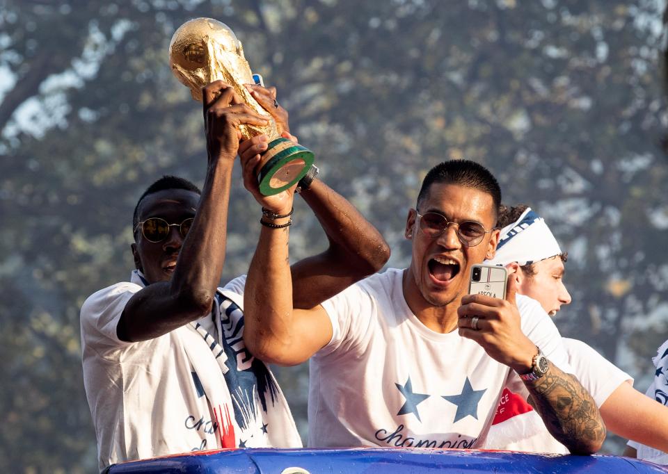  Areola gleefully held the trophy aloft on France's open-top bus tour