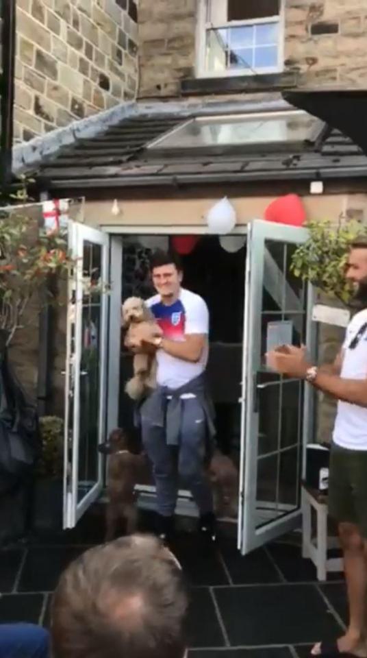  Harry Maguire appeared in the doorway holding a dog as those present cheered his entrance