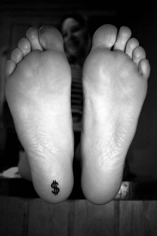  This slightly understated tattoo is of a dollar sign on their heel