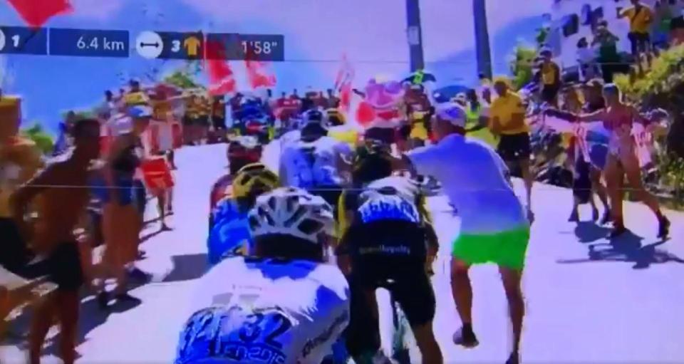 The man wearing green shorts then appears to throw a punch or slap towards Chris Froome