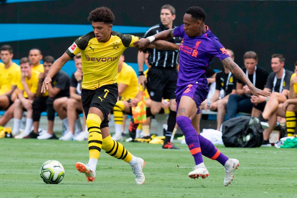 Jadon Sancho holds off a challenge from Nathaniel Clyne