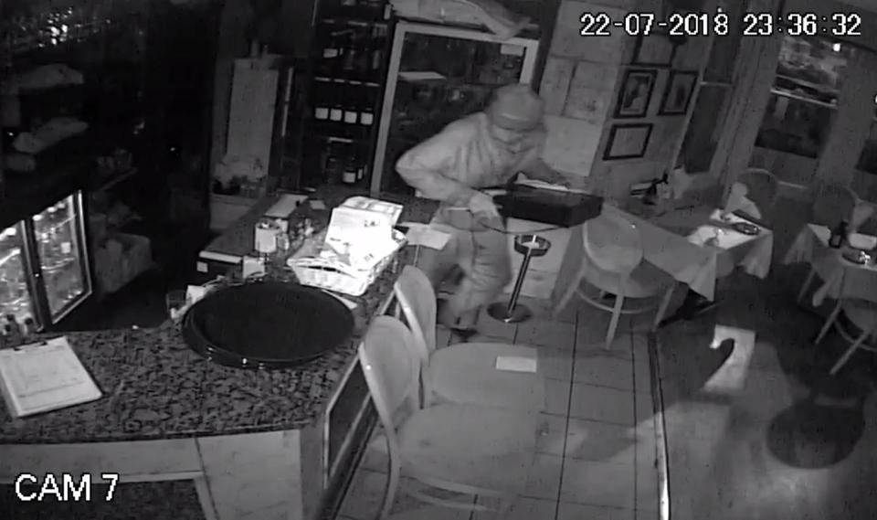  Footage from inside the restaurant in Cardiff shows the suspect creeping in and breaking open the till