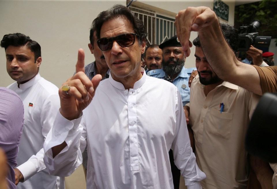 Cricket star-turned-politician Imran Khan, chairman of Pakistan Tehreek-e-Insaf (PTI), arrives at a polling station during Wednesday's general election