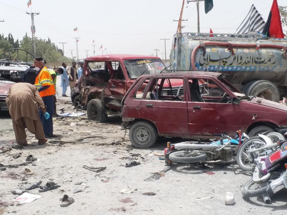  Pakistani security officials inspect the scene of a suspected suicide bomb attack outside a polling station