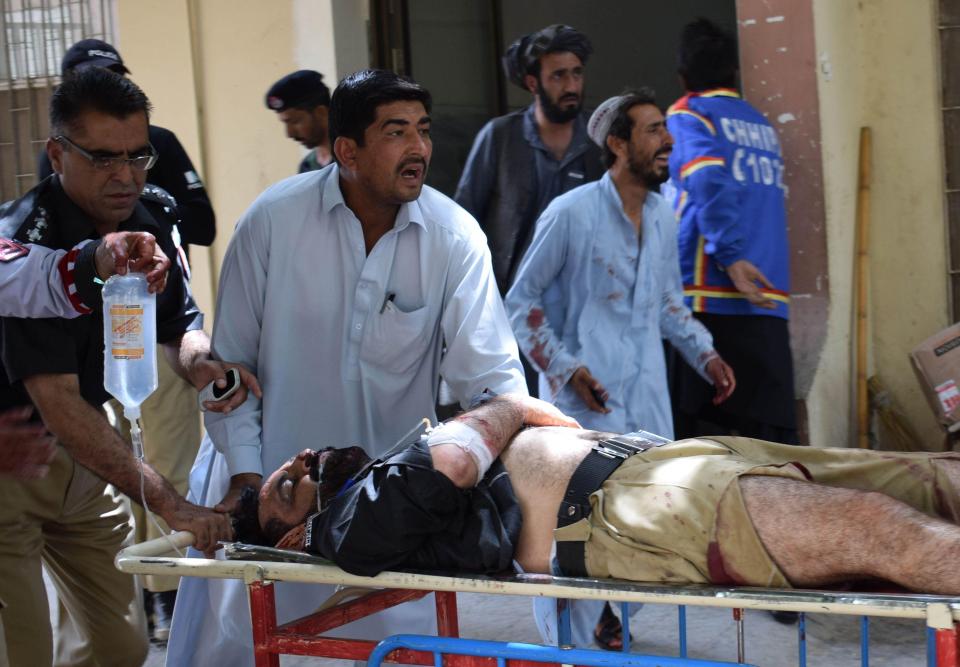  A Pakistani police officer (L) pushes a stretcher carrying one of his injured collegaues