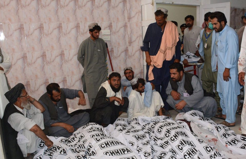  Pakistani relatives mourn beside the bodies of blast victims at a hospital