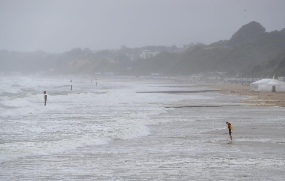  A lifeguard stands on Bournemouth beach in Dorset, as heavy rain and gusts of up to 50mph saw the weekend washout continue following weeks of hot, dry weather